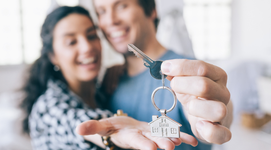 First home buyers celebrating with a key to their home